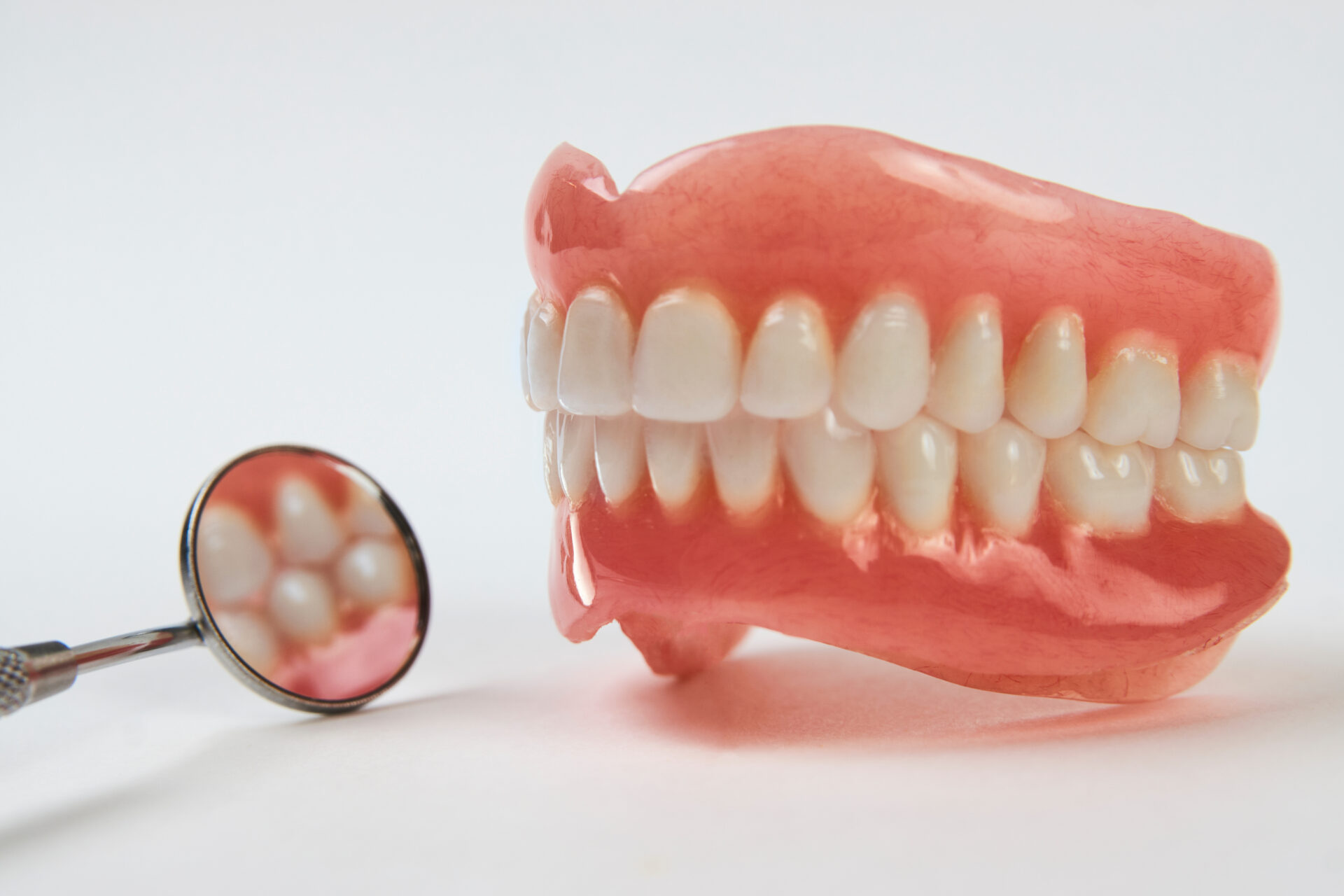 Artificial teeth on a white background with copy space.